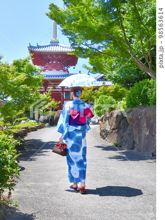 浴衣姿でお寺参りする女性 98563614
