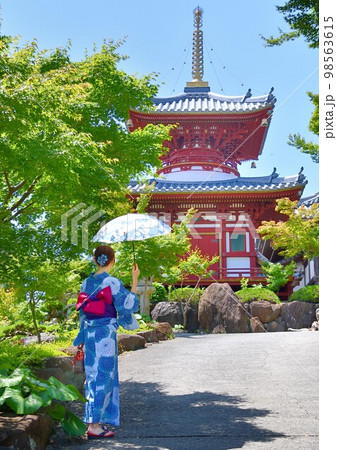 浴衣姿でお寺参りする女性 98563615