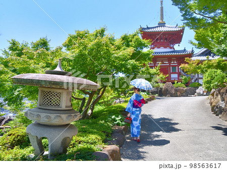 浴衣姿でお寺参りする女性 98563617