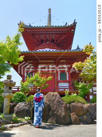 浴衣姿でお寺参りする女性 98563619