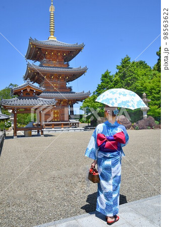 浴衣姿でお寺参りする女性 98563622