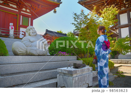 浴衣姿でお寺参りする女性 98563623