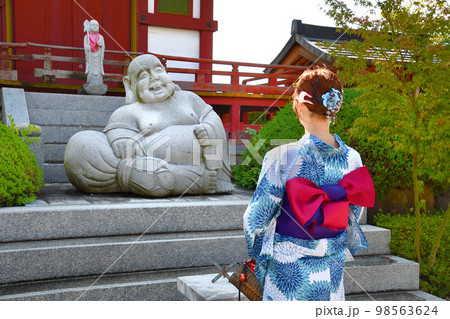 浴衣姿でお寺参りする女性 98563624