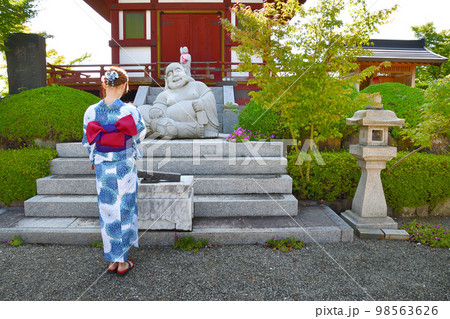 浴衣姿でお寺参りする女性 98563626