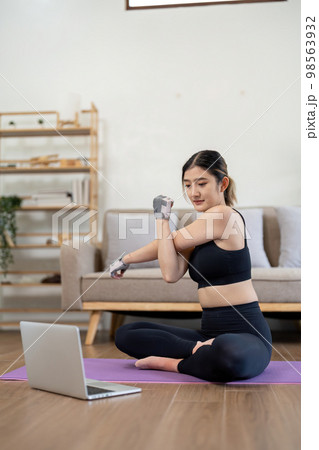 sport, fitness and healthy lifestyle concept - Portrait happy smiling young asian woman with laptop computer stretching arm at home 98563932