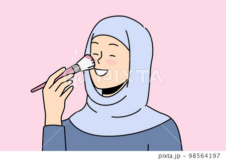Smiling woman in hijab doing makeup Smiling woman in hijab doing makeup 98564197