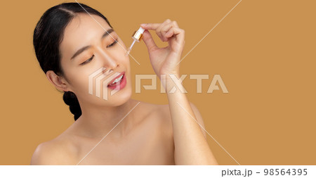Beauty asian woman portrait dropping essential oil on clean face. Beauty asian woman portrait dropping essential oil on clean face. 98564395