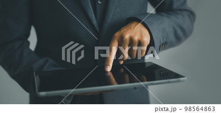 Businessman using a tablet in hand, technology concept background. Businessman using a tablet in hand, technology concept background. 98564863