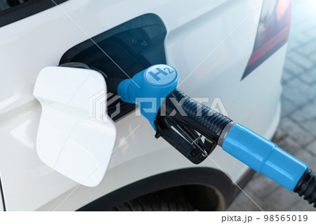 A man fuels a car with hydrogen. A man fuels a car with hydrogen. 98565019