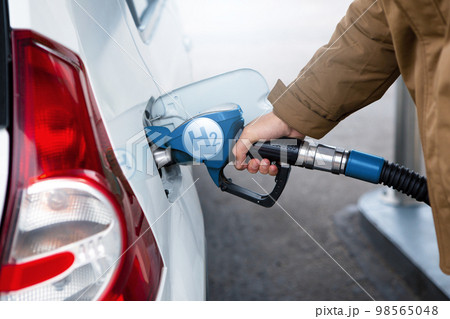 A man fuels a car with hydrogen. 98565048