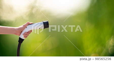 Hand with charger plug for electric car 98565256