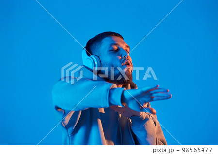 man with headphones in sweatshirt enjoying favorite music 98565477