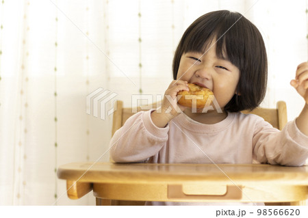 座ってドーナッツを食べる赤ちゃん（2歳4か月、女の子、日本人） 98566620