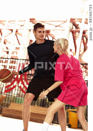 Diversity guy and girl playing basketball on the city playground 98566793