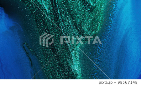 Glitter ink. Abstract background. Sparkling wave. Defocused shiny shimmering green blue color liquid paint blend grain texture with free space. 98567148