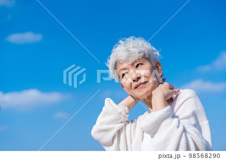 青空の下でストレッチをするシニアの女性 98568290