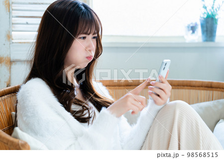 怒ってスマホを使う若い女性 怒ってスマホを使う若い女性 98568515
