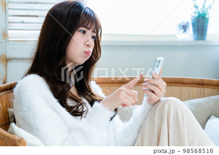 怒ってスマホを使う若い女性 怒ってスマホを使う若い女性 98568516