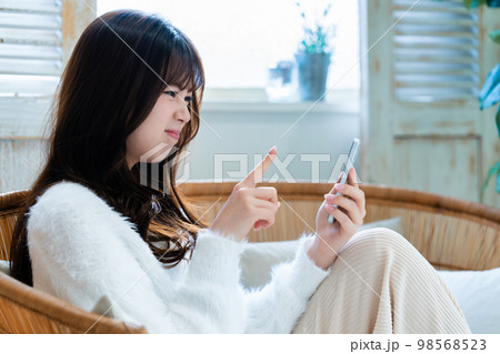 怒ってスマホを使う若い女性 怒ってスマホを使う若い女性 98568523