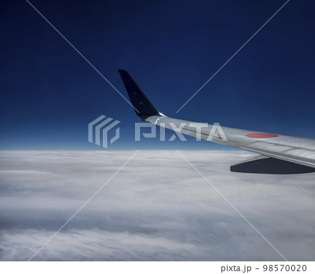 空を飛ぶジェット機の翼 98570020