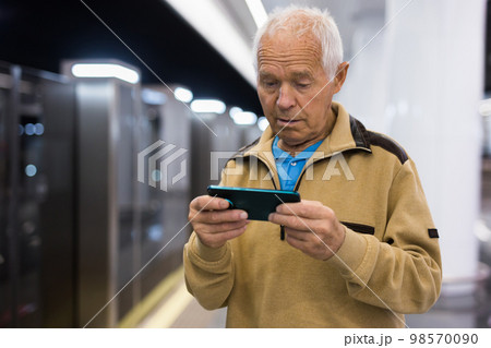 Senior man with smartphone waiting in subway station 98570090