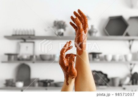 An expert potter, in his laboratory. The artisan creates works of art with his hands. Concept of: experience, art, tradition, clay. Banner, copy space An expert potter, in his laboratory. The artisan creates works of art with his hands. Concept of: experience, art, tradition, clay. Banner, copy space 98571037