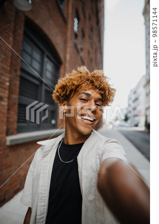 POV Vertical photo of multiracial guy smiling while making selfie by the camera 98571144