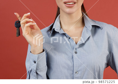 Young smiling satisfied successful woman in shirt hold new apartment key in hands Young smiling satisfied successful woman in shirt hold new apartment key in hands 98571225