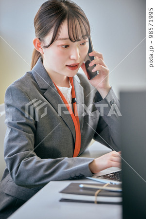 デスクで電話をする若い女性 98571995