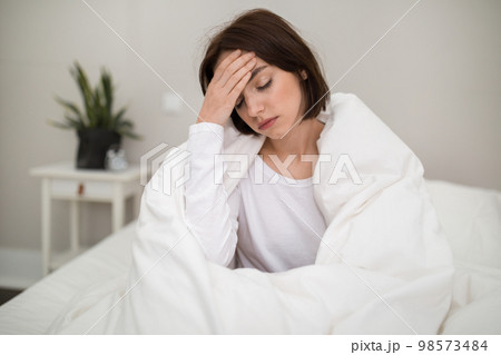 Sick young woman waking up with headache in the morning Sick young woman waking up with headache in the morning 98573484