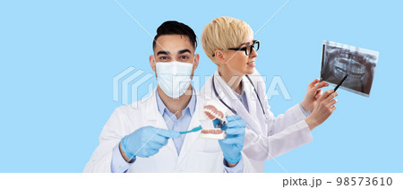 International group of dentists man and woman posing on blue 98573610