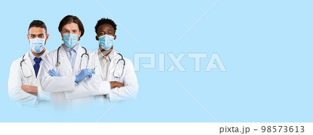 Men in medical face masks doctors posing on blue 98573613