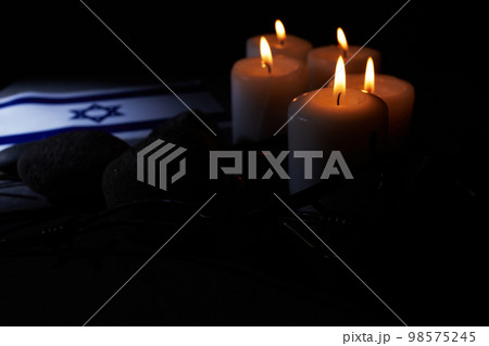 Burning candle, Barbed wire, flag of Israel on dark background. Holocaust memory day Burning candle, Barbed wire, flag of Israel on dark background. Holocaust memory day 98575245