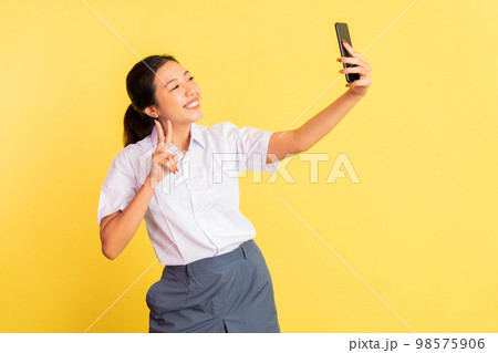 girl school selfie using handphone with v sign hand gesture girl school selfie using handphone with v sign hand gesture 98575906