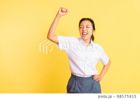 excited teenage girl in high school uniform while celebrating something 98575915