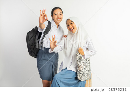 two smiling vocational high school girls with ok hand gesture 98576251