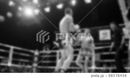 Blurred images black and white photo style of Thai boxing or Muay Thai or Kickboxing which local and foriegn boxer are fighting on the ring at indoor stage as martial art sport. Muay Thai Kick boxing Blurred images black and white photo style of Thai boxing or Muay Thai or Kickboxing which local and foriegn boxer are fighting on the ring at indoor stage as martial art sport. Muay Thai Kick boxing 98576456