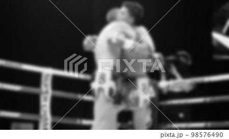 Blurred images black and white photo style of Thai boxing or Muay Thai or Kickboxing which local and foriegn boxer are fighting on the ring at indoor stage as martial art sport. Muay Thai Kick boxing Blurred images black and white photo style of Thai boxing or Muay Thai or Kickboxing which local and foriegn boxer are fighting on the ring at indoor stage as martial art sport. Muay Thai Kick boxing 98576490