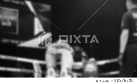 Blurred images black and white photo style of Thai boxing or Muay Thai or Kickboxing which local and foriegn boxer are fighting on the ring at indoor stage as martial art sport. Muay Thai Kick boxing 98576500