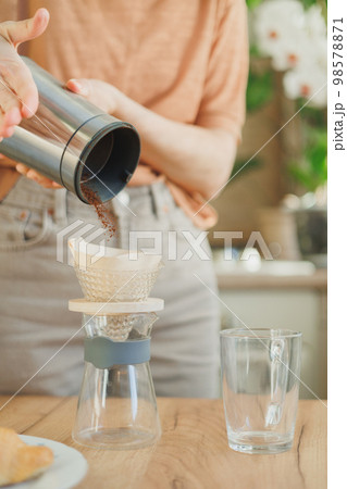 woman makes coffee in morning for breakfast, brew drip purover. americano cappuccino. woman makes coffee in morning for breakfast, brew drip purover. americano cappuccino. 98578871