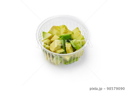 Pieces of soft ripe avocado in disposable plastic bowl 98579090