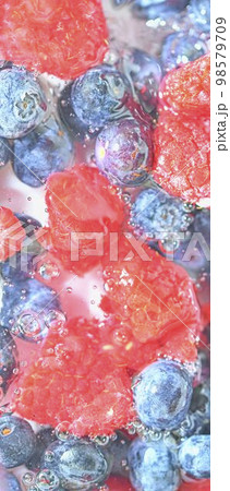 Blueberries and raspberries in liquid with bubbles. Colourful ripe bilberries and raspberries in water. Close-up of fresh berries in water background. Top view, flat design. Vertical macro image Blueberries and raspberries in liquid with bubbles. Colourful ripe bilberries and raspberries in water. Close-up of fresh berries in water background. Top view, flat design. Vertical macro image 98579709