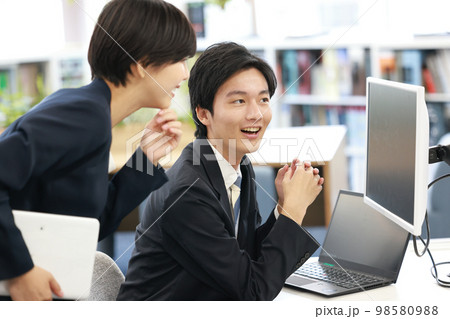 作成中の資料について相談するビジネスマンとアドバイスする女性2 98580988