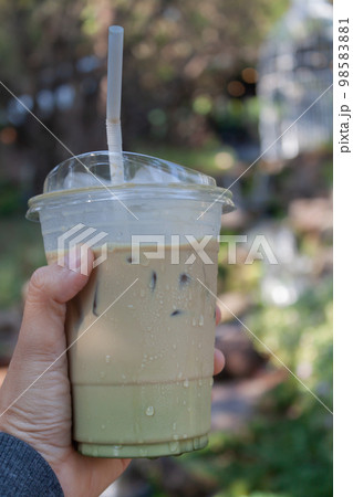 Woman hold her iced coffee Woman hold her iced coffee 98583881