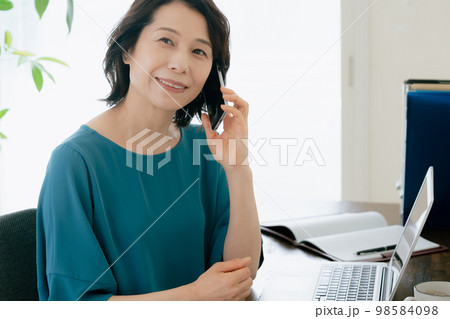 スマホで通話するミドル女性 98584098