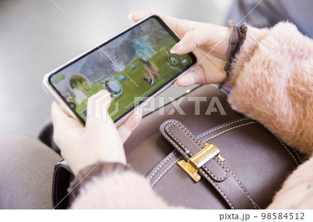 電車内でスマホゲームをする若い女性手元 電車内でスマホゲームをする若い女性手元 98584512