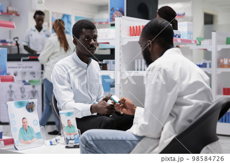 Pharmacy consultation, african american patient measuring glucose with glucometer, diabetes diagnosis in drugstore. Blood sugar level control, medical service, healthcare 98584726