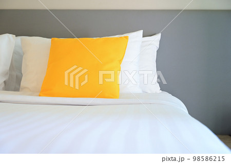 yellow pillow on white bed, interior design 98586215