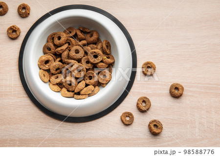 A bowl of dog food on a wooden floor. A bowl of dog food on a wooden floor. 98588776