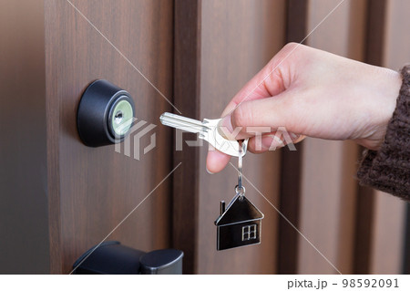 玄関ドアの施錠をする女性の手元 玄関ドアの施錠をする女性の手元 98592091